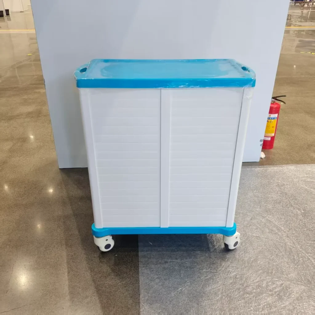 A blue and white storage cabinet with wheels, placed on a tiled floor. It has a plastic construction with a flat top.