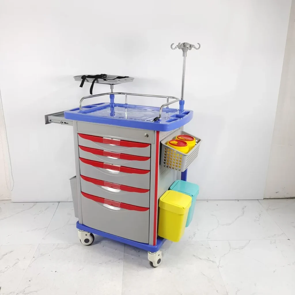 Medical emergency trolley with red drawers, blue top, and attached bins, used in hospitals for quick access to supplies.