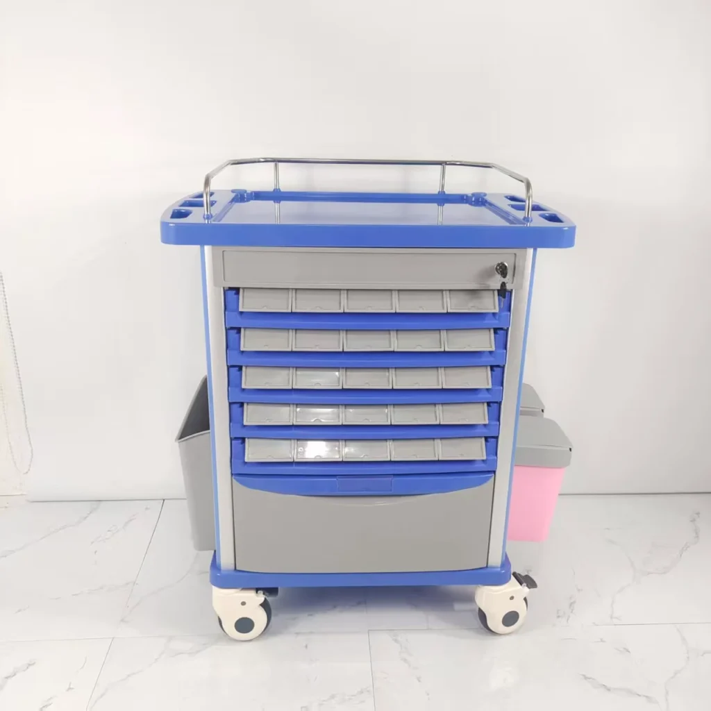 A medical trolley featuring multiple drawers, blue accents, and four wheels on a tiled floor surface.