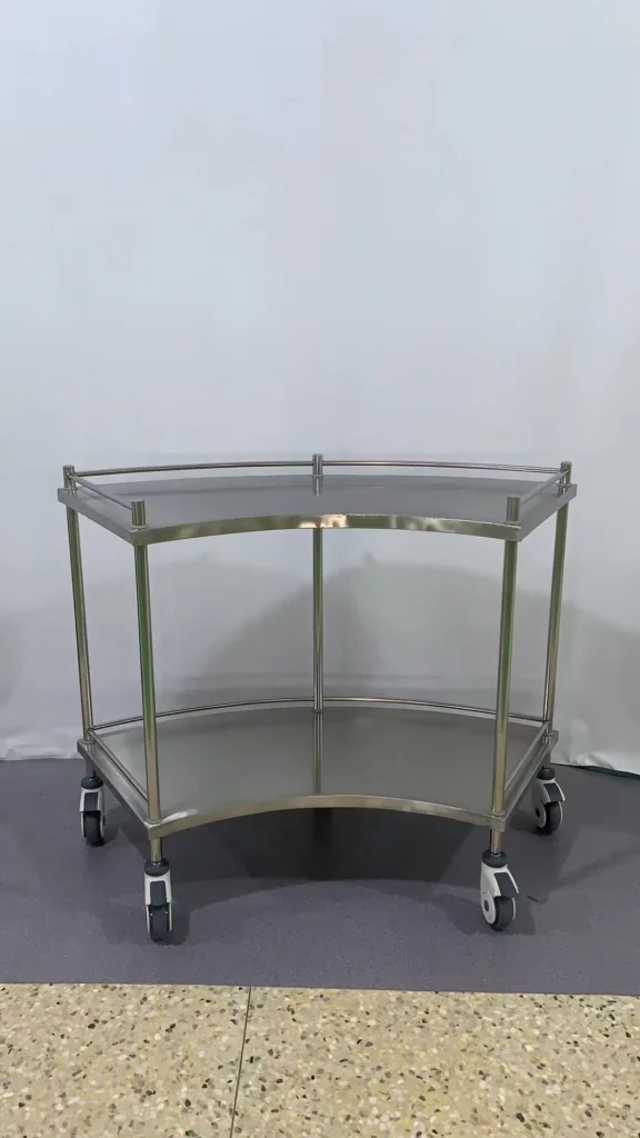 Stainless steel trolley with curved design and caster wheels for mobility, set against a neutral background.