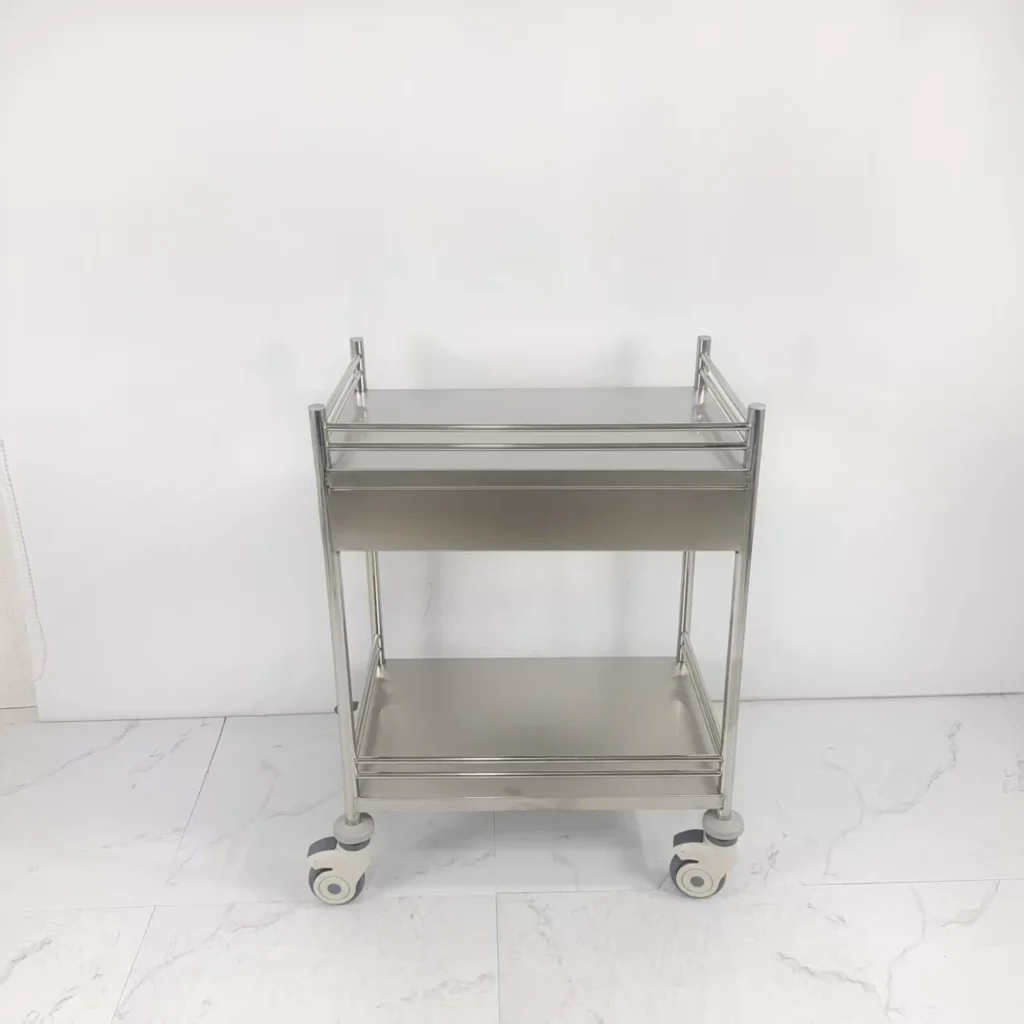 Stainless steel utility cart with two shelves and wheels on a white tiled floor.