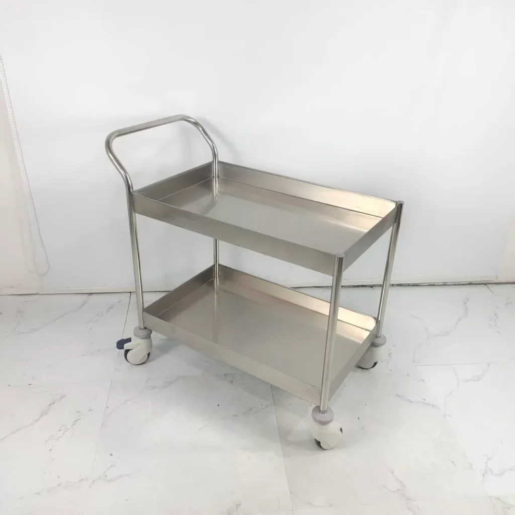 Stainless steel two-tier utility cart on wheels, featuring a handle for easy maneuverability on a tiled floor.