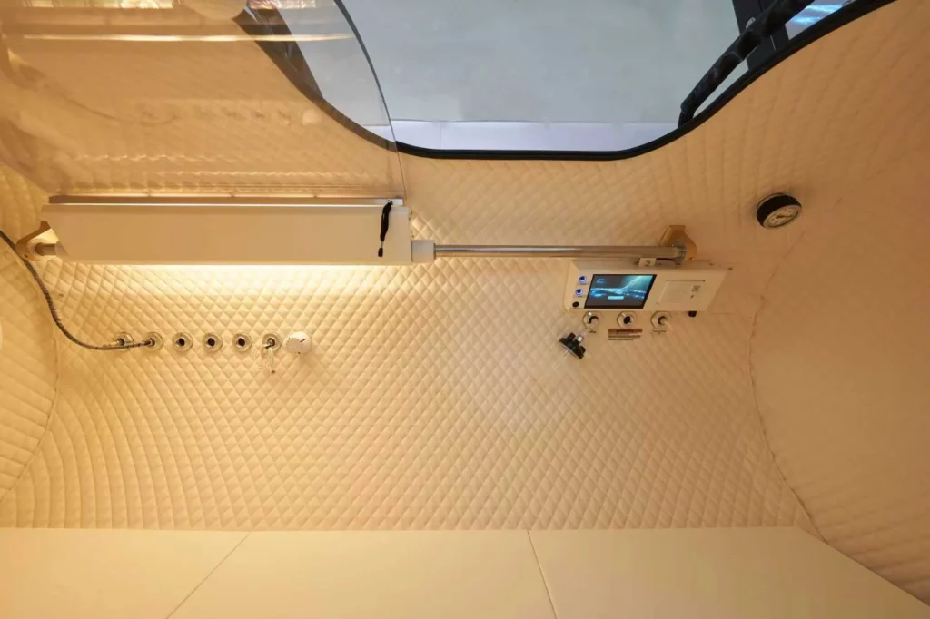 Quilted bathroom shower panel with modern controls, featuring a digital screen and sleek metallic fixtures.