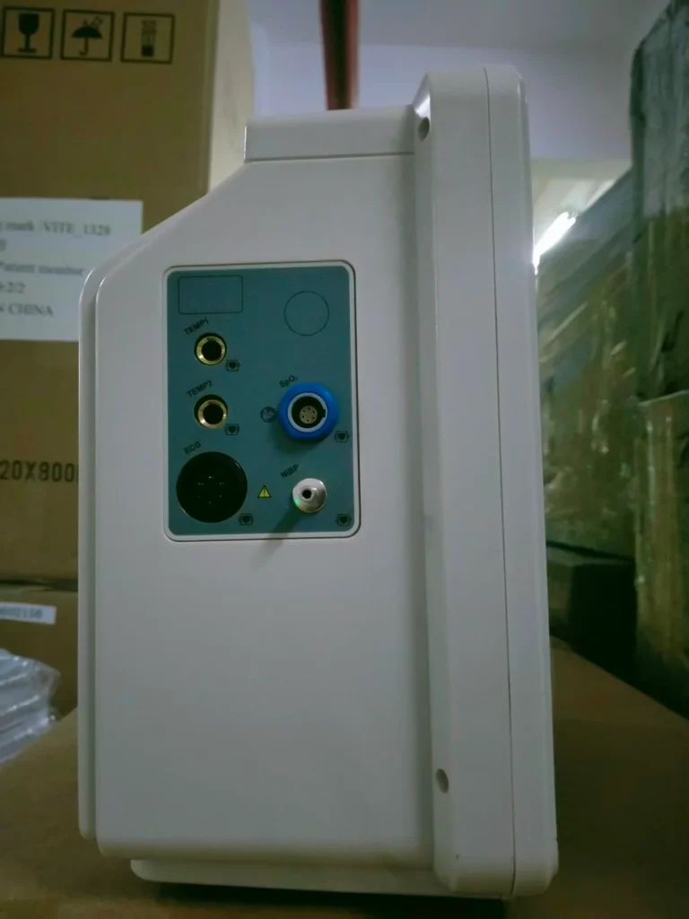 Side view of a medical device showing various connectivity ports including Temp1, Temp2, ECG, and SpO2 inputs.