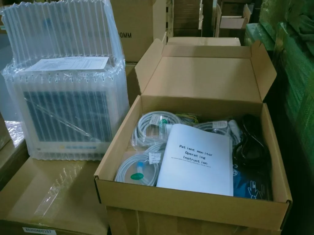 Box containing medical equipment and patient monitor instructions in a warehouse setting.