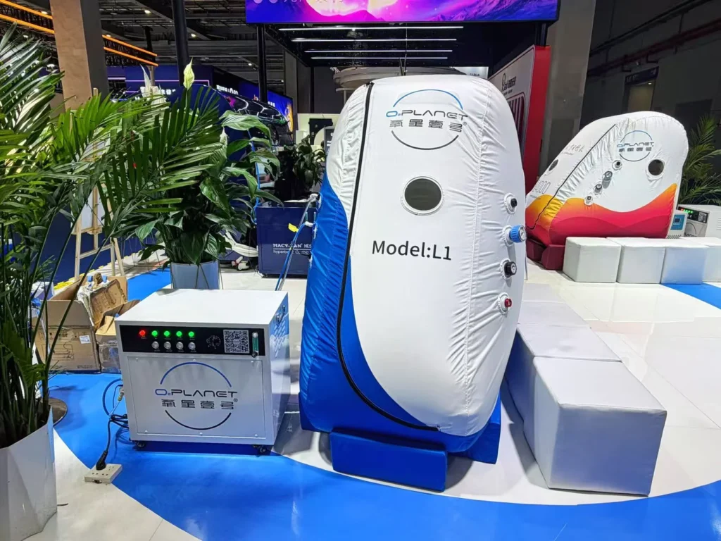 O.Planet Model L1 device with white and blue casing displayed at a trade show, surrounded by plants and technology exhibits.