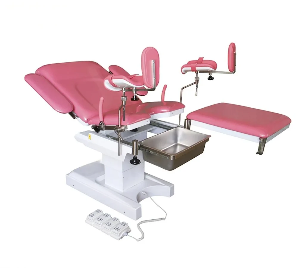 Pink medical examination chair with adjustable footrests, armrests, and a stainless steel basin, designed for gynecological use.