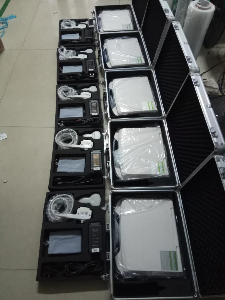 Several portable medical devices neatly organized in open carrying cases, each with accompanying wires and components.