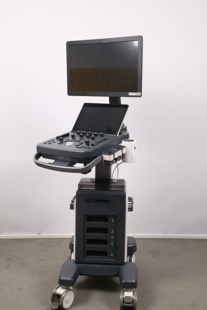 A modern ultrasound machine with a monitor, control panel, and mobile base with wheels, displayed against a plain background.