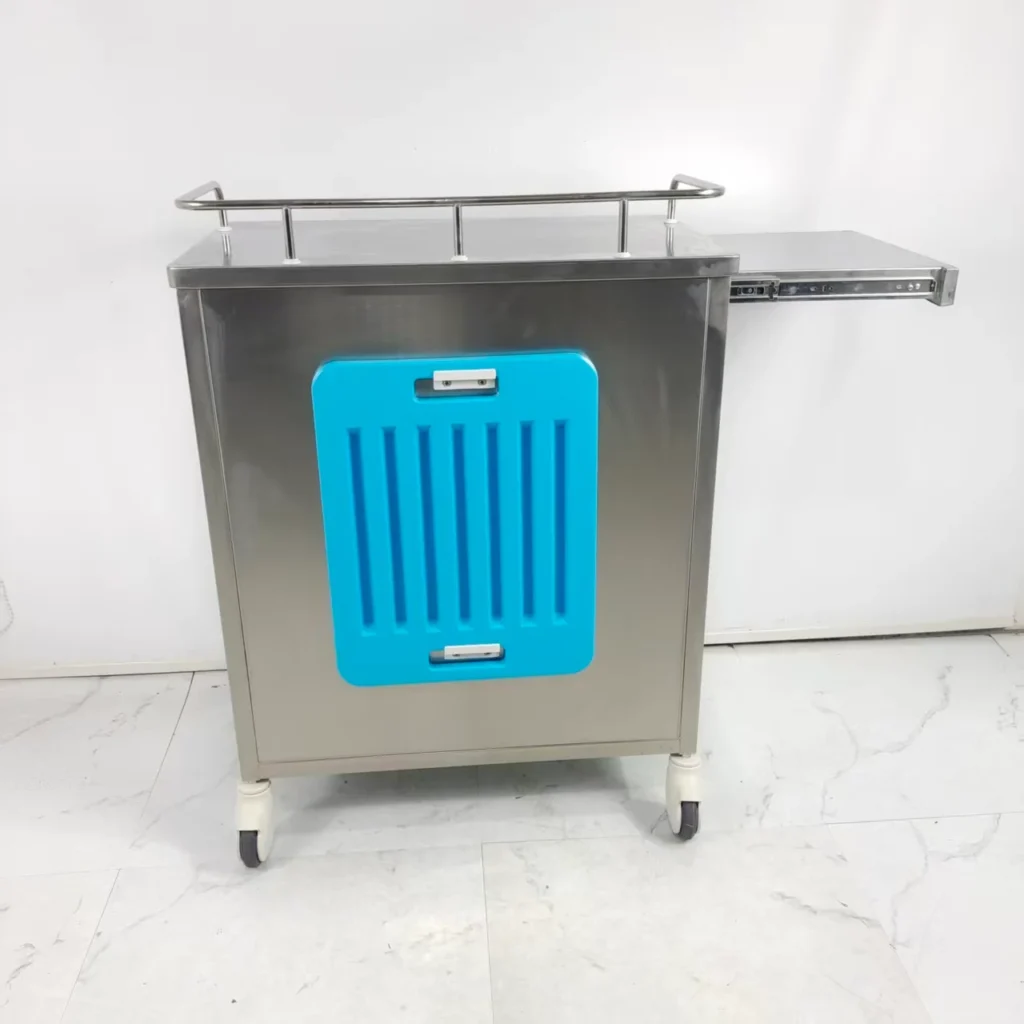 Stainless steel medical cart with a bright blue vented panel, swivel caster wheels, and a retractable side tray, placed on a tiled floor.