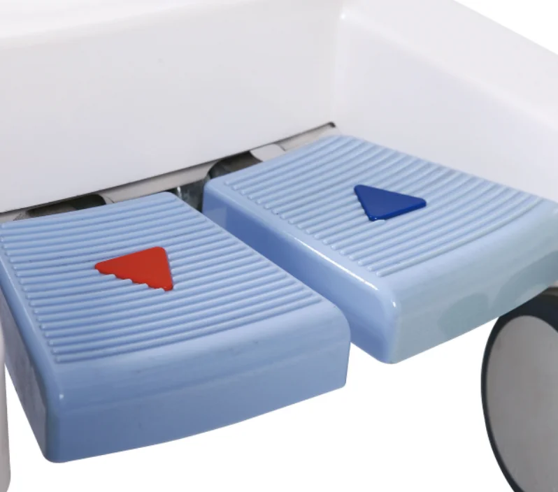 Close-up view of blue medical pedal controls featuring red and blue triangular indicators, shown on a white apparatus.