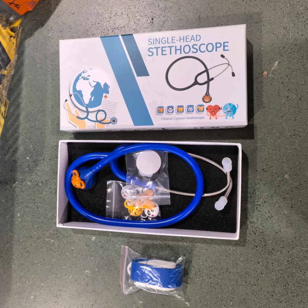 Children's cartoon-themed single-head stethoscope kit, featuring a blue stethoscope with animal designs, packaged in a box on a green surface.