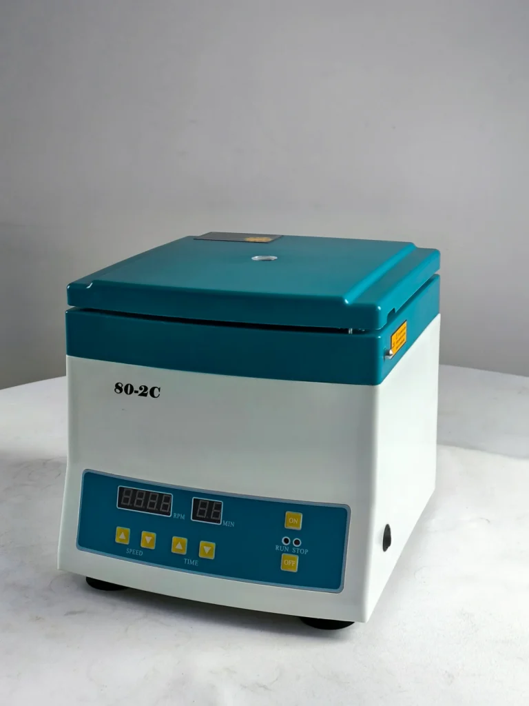 A compact laboratory centrifuge model 80-2C with a green lid and digital controls, placed on a white surface.