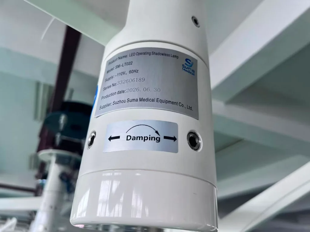 Close-up of a label on an LED operating shadowless lamp showing specifications, production details, and a damping adjustment sign.