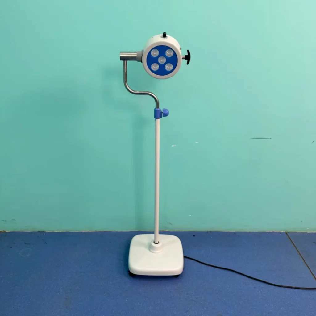 Medical examination lamp on a wheeled base with a blue background, featuring a bright blue head with four circular lights.