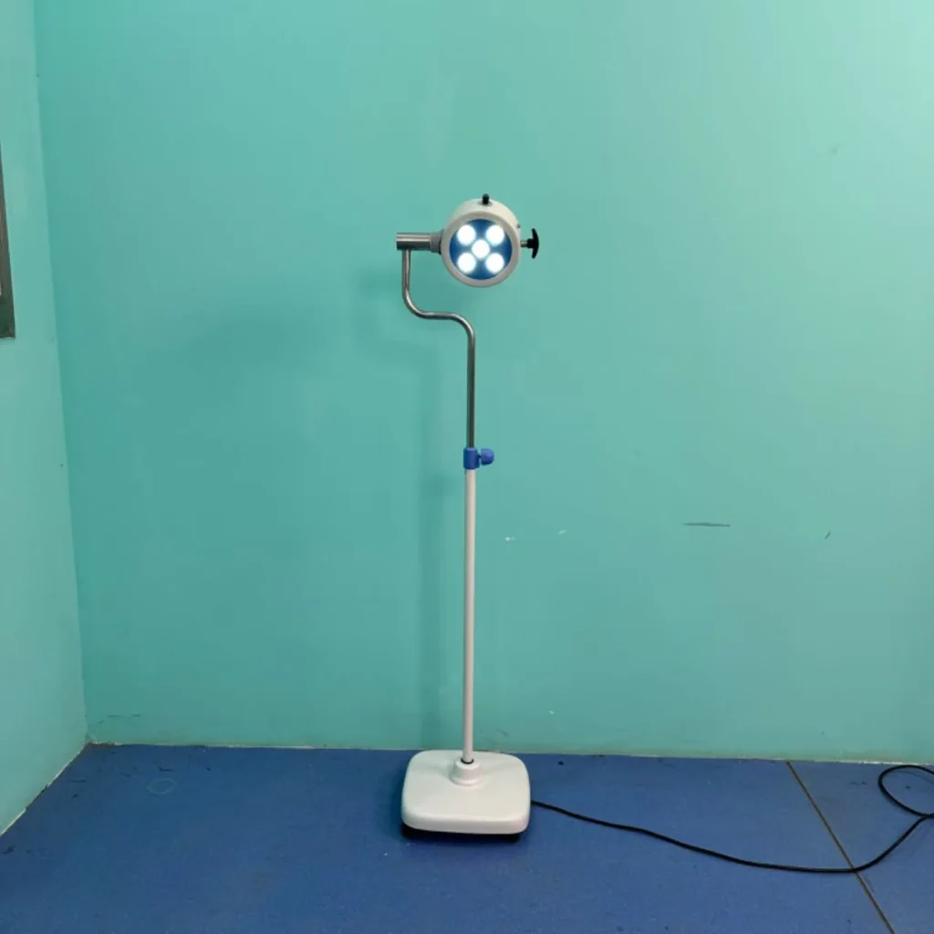 A stand-mounted, adjustable medical examination light with LED bulb array, placed in a blue room on a blue tiled floor.
