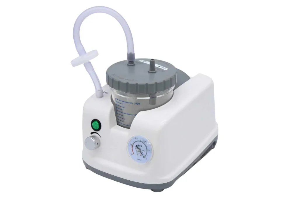 Compact portable medical suction machine with a transparent container, measurement markings, gray lid, connected tubing, and control knobs.