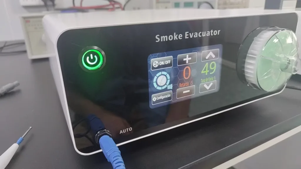 Smoke evacuator device with a touch-enabled digital display showing settings, green power button illuminated, and connected cables on a laboratory table.