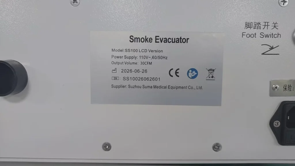 Close-up of a label on a smoke evacuator device, showing model SS100 LCD details, power supply, and supplier information.