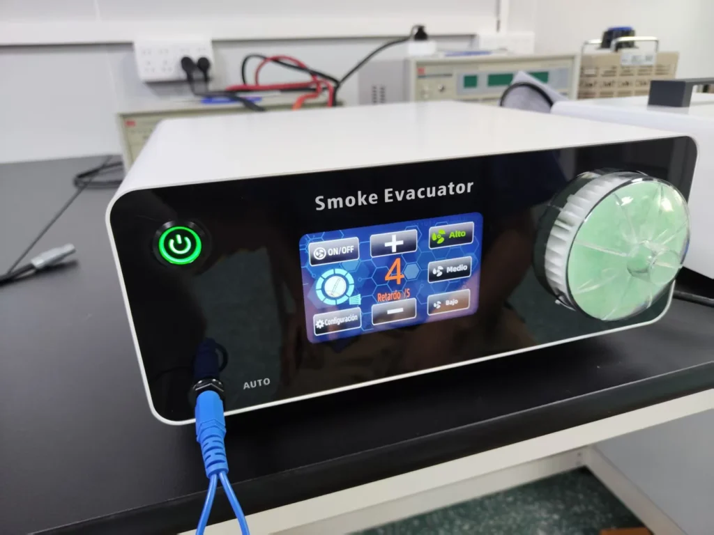 Smoke evacuator machine with a digital touch panel, green power button, and protective filter on a lab table.