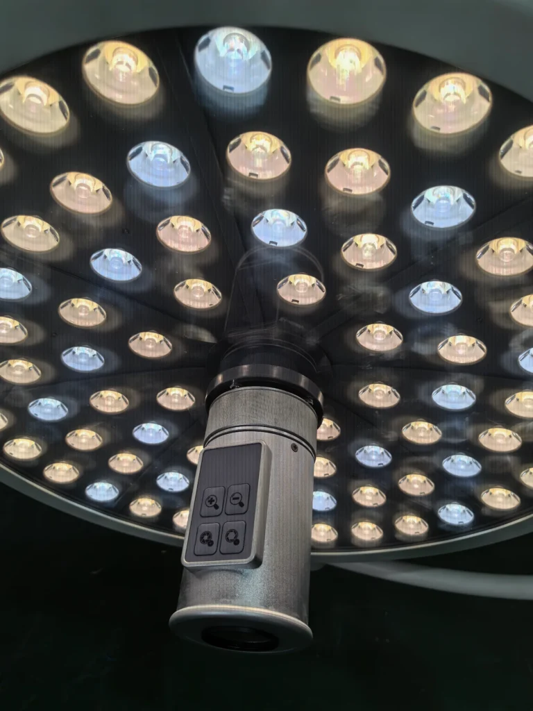 Close-up view of a modern surgical operating light with multiple LED bulbs and control panel, used in medical procedures.