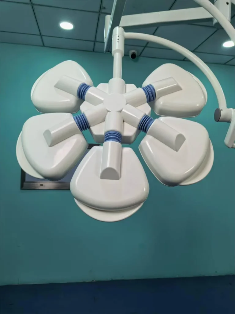 Overhead surgical operating light with a floral design and white panels, mounted on a ceiling in a sterile medical room.