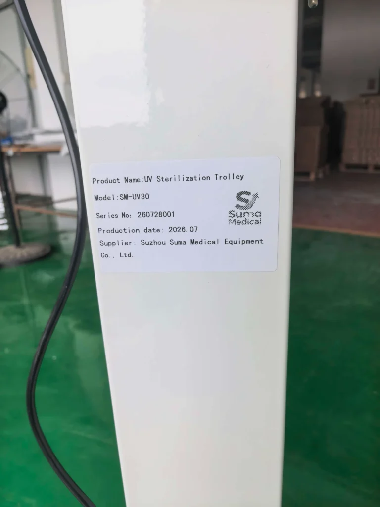 Close-up of a label detailing the product name, model (SM-UV30), serial number, production date, and supplier as Suzhou Suma Medical Equipment Co., Ltd., on a UV sterilization trolley.