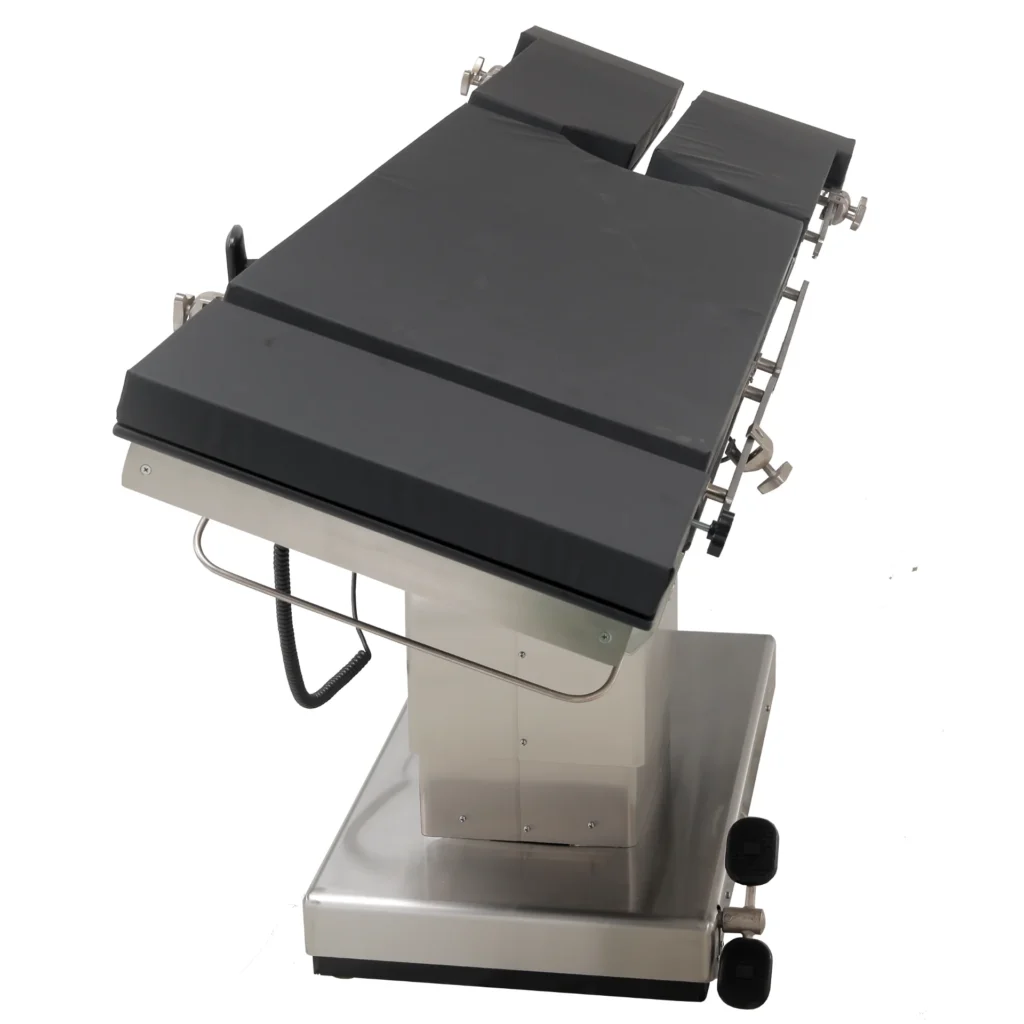 Black-cushioned surgical operating table with adjustable sections, set on a stainless steel base, designed for medical procedures.