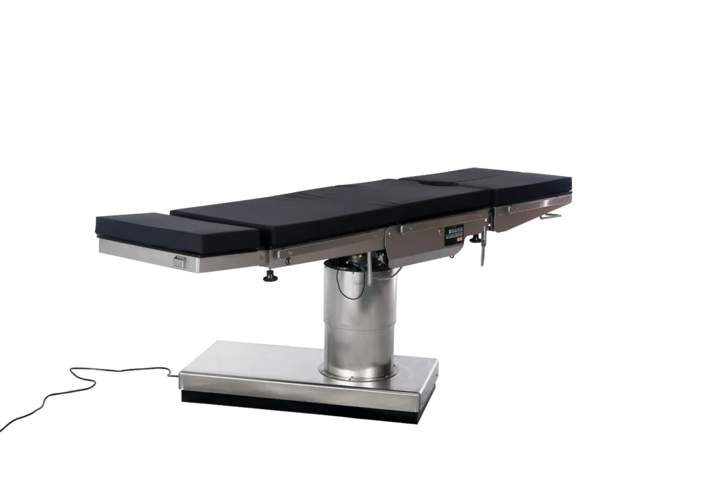 Stainless steel surgical operating table with black cushion, hydraulic base, and control panel, set against a white background.