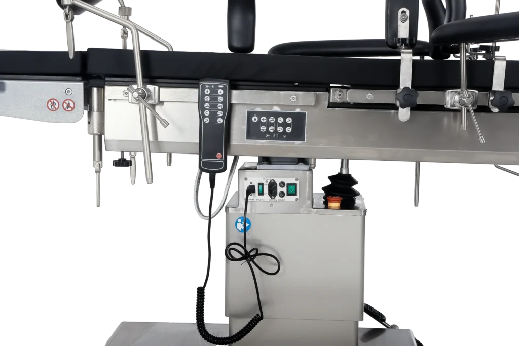 Close-up view of a surgical operating table showing control panel, adjustable mechanisms, and metal components.